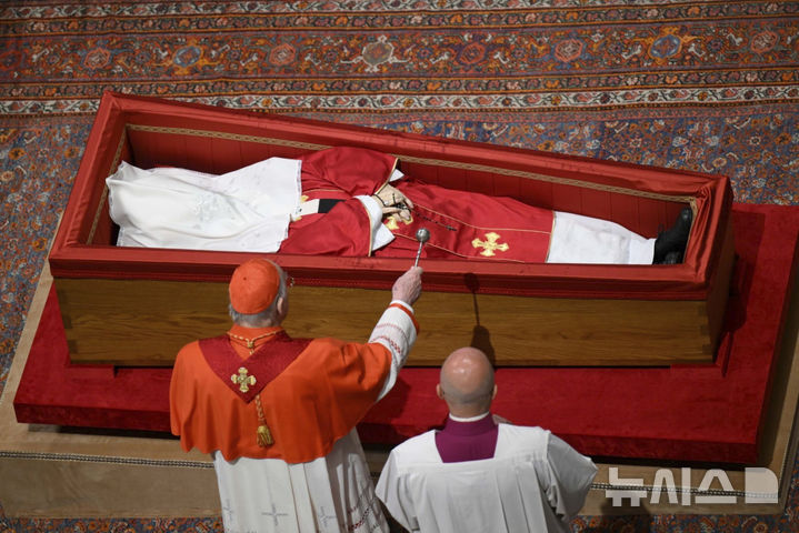 [바티칸=AP/뉴시스] 교황 궁무처장 케빈 조셉 패럴 추기경이 25일(현지 시간) 바티칸 성 베드로 대성당에서 고(故) 프란치스코 교황의 시신이 안치된 관을 덮기 전 시신에 성수를 뿌리고 있다. 2025.04.26.
