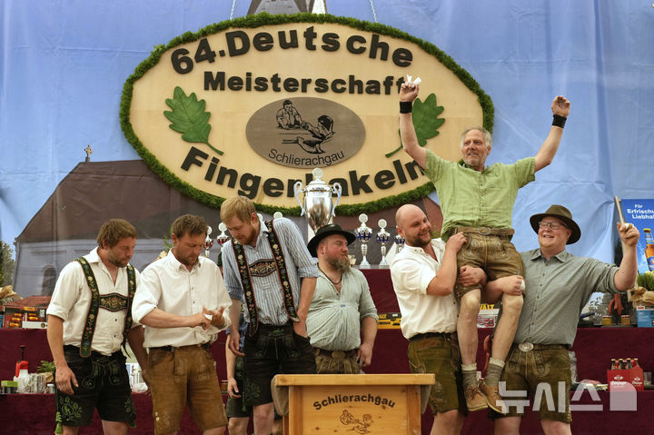 <font style="vertical-align: inherit;"><font style="vertical-align: inherit;">[바이에른=뉴시스] 27일(현지 시간) 독일 바이에른주 로젠하임 인근에서 열린 독일 핑거하켈른(핑거 레슬링) 챔피언십에서 승리한 참가자가 기뻐하고 있다. 2025.04.28.</font></font>