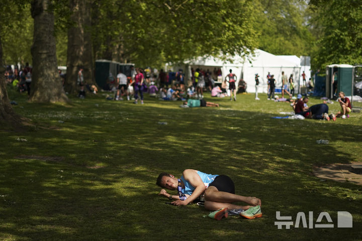 [런던=AP/뉴시스] 27일(현지 시간) 영국 런던에서 열린 2025 런던 마라톤에 참가한 참가자들이 완주 후 세인트 제임스 공원에서 휴식하고 있다. 2025.04.28.