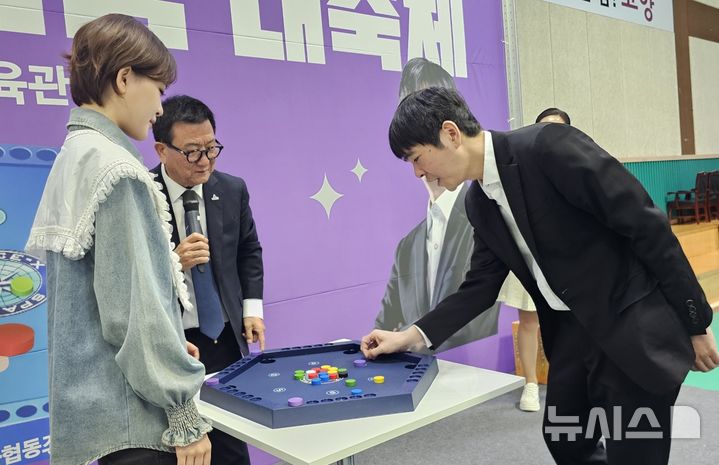 [고양=뉴시스] 김도희 기자 = 27일 경기 고양시 덕양구 어울림누리체육관에서 열린 '고양시 보드게임 가족 한마음 대축제'에서 프로바둑 9단 이세돌 국수와 국악트롯요정 김다현 양이 알까기게임 '스페이스X' 대결을 벌이고 있다. 2025.04.27 kdh@newsis.com 