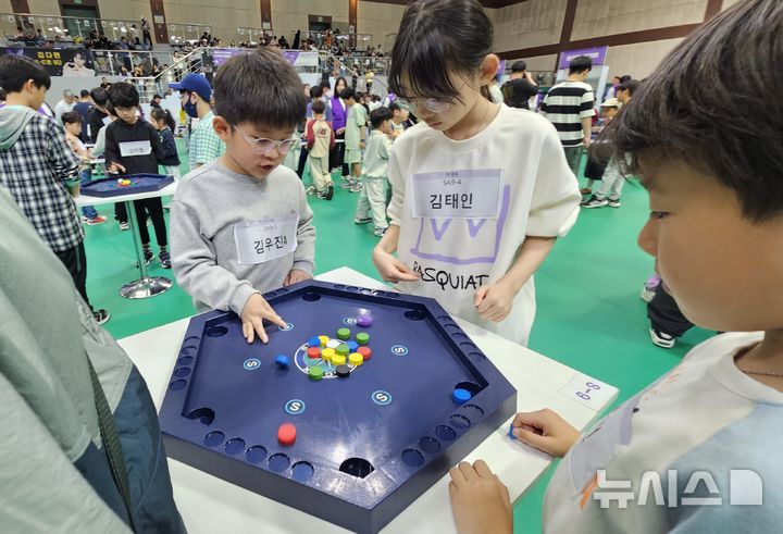 [고양=뉴시스] 송주현 기자 = 27일 경기 고양시 어울림누리 체육관에서 개최되고 있는 '고양시 보드게임 가족 한마음 대축제'에서 참가자들이 알까기와 포켓볼을 결합한 '스페이스X' 보드게임을 하고 있다. 2025.04.27 atia@newsis.com 