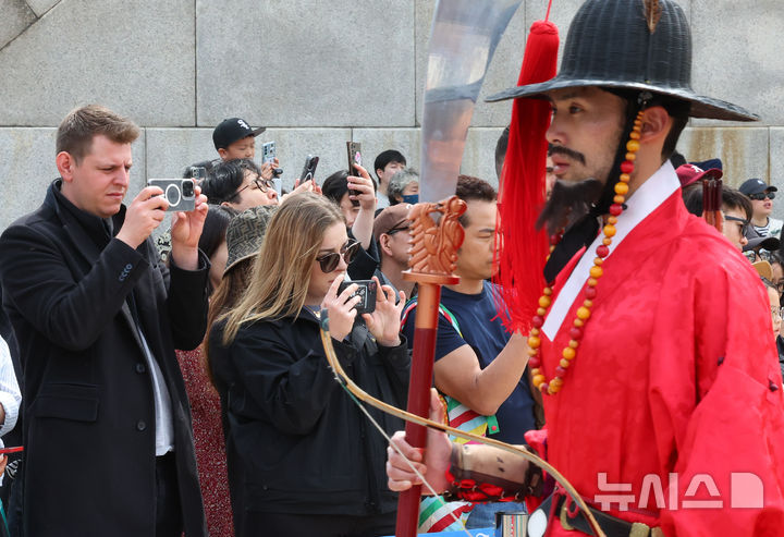 [서울=뉴시스] 최진석 기자 = 궁중문화축전 2일차인 27일 오후 서울 종로구 경복궁에서 외국인들이 수문장 교대의식을 스마트폰으로 촬영하고 있다. ‘궁중문화축전’은 대한민국을 대표하는 문화유산이며 조선과 대한제국의 역사를 품고 있는 경복궁, 창덕궁, 창경궁, 덕수궁, 경희궁 등 서울 소재 5개의 궁궐과 종묘에서 펼쳐지는 문화유산 축제이다. 2025.04.27. myjs@newsis.com