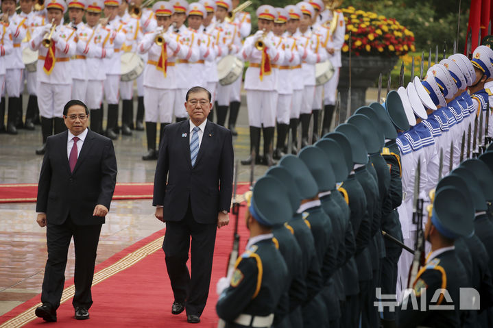 [하노이=AP/뉴시스] 이시바 시게루(오른쪽) 일본 총리가 28일(현지 시간) 베트남 하노이 주석궁에서 팜민찐 베트남 총리와 함께 베트남 의장대를 사열하고 있다. 2025.04.28.