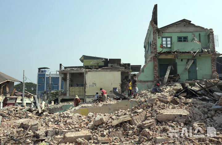 [네피도=AP/뉴시스] 지난 3월 발생한 강진으로 인한 미얀마 정부군과 반군 간의 일시 휴전이 1일 종료됐다. 사진은 지난달 28일 미얀마 네피도에서 자원봉사자들이 붕괴한 건물 정리를 돕는 모습. 2025.05.01