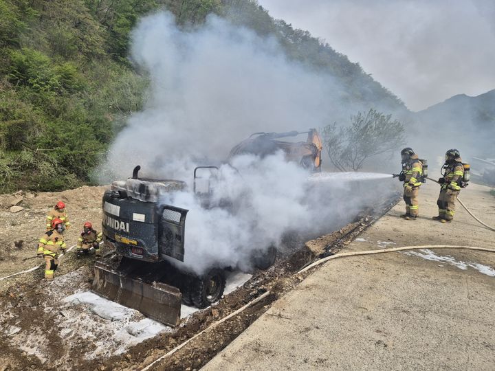 [금산=뉴시스] 지난 27일 오후 2시47분께 충남 금산군 남이면 역평리 하천공사 현장에서 작업 중이던 굴착기에서 불이 나 현장에 출동한 소방대원들이 진화에 나서고 있다. (사진=금산소방서 제공) 2025.04.28. photo@newsis.com *재판매 및 DB 금지