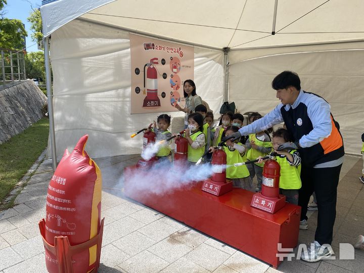 [세종=뉴시스]안전꿈나무를 위한 안전문화 체험행사에서 어린이들이 소화기 사용법을 체험하고 있는 모습.(사진=동서발전 제공)