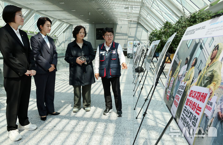[서울=뉴시스] 조성우 기자 = 사진은 기사와 무관. 김재연(왼쪽 두 번째부터) 진보당 제21대 대통령 선거 후보와 고 김용균 어머니 김미숙 김용균재단 이사장, 정혜경(왼쪽) 의원이 28일 오후 서울 여의도 국회 의원회관 로비에서 열린 4.28 산업재해 노동자의 날 국가기념일 지정 첫 해 기념 '싸우는 산재노동자 사진전'에서 작품을 관람하고 있다. 2025.04.28. xconfind@newsis.com