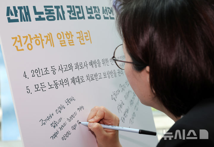 [서울=뉴시스] 조성우 기자 = 정혜경 진보당 의원이 28일 오후 서울 여의도 국회 의원회관 로비에서 개막한 4.28 산업재해 노동자의 날 국가기념일 지정 첫 해 기념 '싸우는 산재노동자 사진전'에서 추모 메시지를 적고 있다. 2025.04.28. xconfind@newsis.com