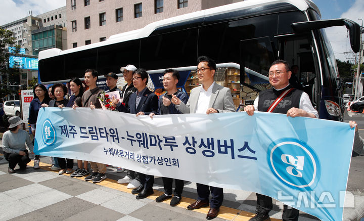 [제주=뉴시스] 우장호 기자 = 28일 오후 제주시 연동 누웨마루거리 입구에서 '제주드림타워 복합리조트-누웨마루거리 상생버스'를 타고 온 외국인 고객들과 누웨마루거리상점가상인회, 제주드림타워 관계자들이 기념촬영을 하고 있다. 이날 운행을 시작한 상생버스는 제주 드림타워를 방문한 외국인 고객들이 누웨마루거리에 보다 손쉽게 접근하고 상인들에도 보탬이 될 수 있게 누웨마루거리상점가상인회와 협의를 거쳐 마련됐다. 2025.04.28. woo1223@newsis.com