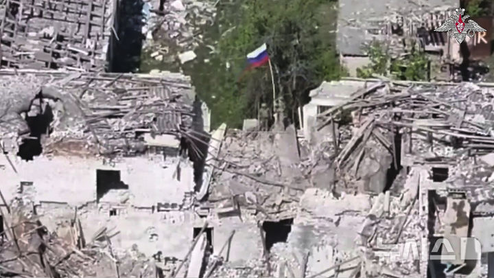 [카미얀카=AP/뉴시스] 지난달 28일(현지 시간) 러시아 군인 2명이 우크라이나 하르키우주 카미얀카의 한 건물 위에 러시아 국기를 게양하고 있다. 2025.05.26.