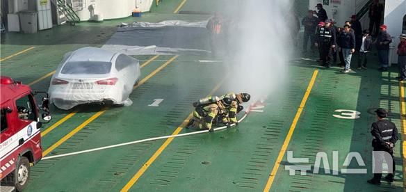 [서울=뉴시스] 한국해양교통안전공단(KOMSA)이 관계 기관과 함께 시행한 여객선 전기차 화재 대응훈련 모습.