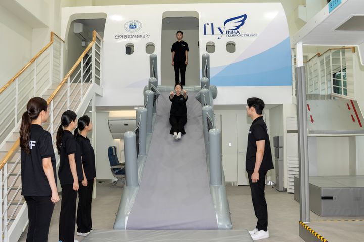 [인천=뉴시스] 28일 인천 미추홀구 인하공업전문대학 항공안전훈련실습실에 마련된 보잉 737기종의 비상탈출용 슬라이드에서 한 학생들이 실습을 하고 있다. (사진=인하공전 제공) 2025.04.29. photo@newsis.com *재판매 및 DB 금지