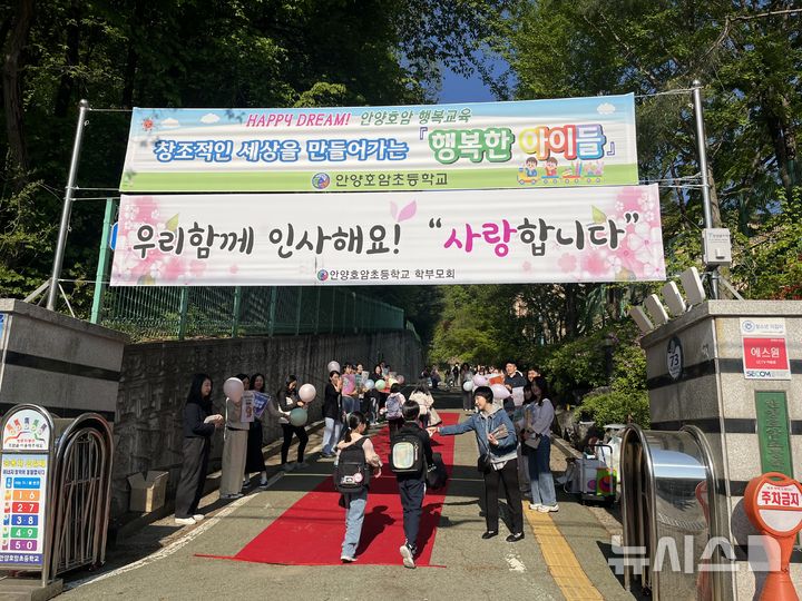 [안양=뉴시스] 호암초 학부모회가 학교 정문에서 어린이 날 ‘특별한 등교 행사’를 진행하고 있다. (사진=학부모회 제공).2025.04.29. photo@newsis.com