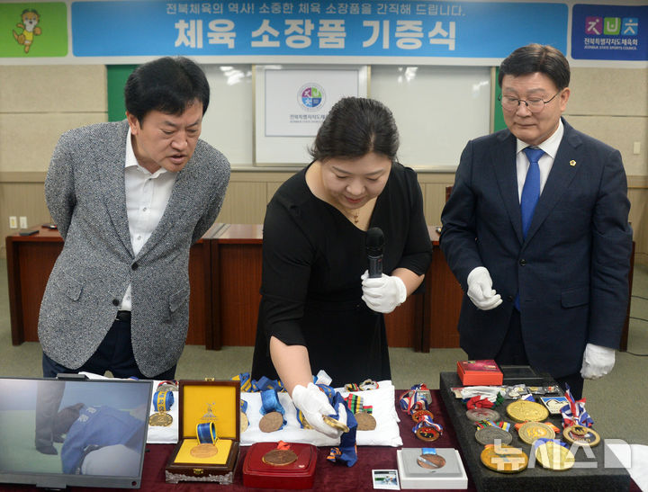 [전주=뉴시스] 김얼 기자 = 정경미(가운데) 베이징 올림픽 여자 유도 동메달 메달리스트가 29일 전북 전주시 전북특별자치도체육회관을 방문해 '전북체육 역사기념관 건립을 위한 소장품 기증식'을 열고 기증품을 설명하고 있다. 2025.04.29. pmkeul@newsis.com