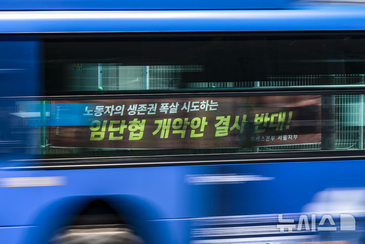 [서울=뉴시스] 정병혁 기자 = 29일 서울시내 차고지 인근에서 달리는 버스 뒤로 공공운수노조 민주버스본부 서울지부에서 내건 현수막이 보이고 있다. 서울 시내버스 노사가 쟁의 행위 개시일을 하루 앞두고 협상에 나선다. 전날 노조가 실시한 쟁의 행위 찬반 투표에서는 투표 인원 대비 96.3%, 전체 조합원 대비 84.9%가 쟁의 행위에 찬성했다. 서울 시내버스 노사는 지난해 12월부터 이달 3일까지 열린 9차례 중앙 노사 교섭과 서울지방노동위원회 사전 조정 회의에서 합의에 이르지 못했다.노사 간 막판 협의가 무산되면 30일 첫차부터 쟁의 행위가 시작될 전망이다. 노조 예고대로 30일 첫차부터 '준법 투쟁', '안전 운행 캠페인' 등 쟁의행위가 시작될 경우 운행 지연, 배차 간격 증가 등 시내버스 운영 차질이 발생할 것이라고 시는 전망했다. 2025.04.29. jhope@newsis.com