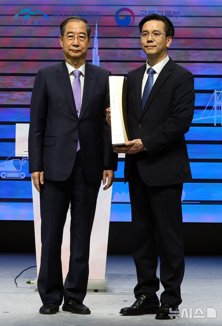 [서울=뉴시스] 최진석 기자 = 한덕수 대통령 권한대행 국무총리가 29일 서울 강남구 건설회관에서 열린 해외건설 1조달러 수주 및 60주년 기념식에서 이한우 현대건설 대표이사에게 해외건설의 탑을 수여 뒤 기념촬영하고 있다. 2025.04.29. myjs@newsis.com