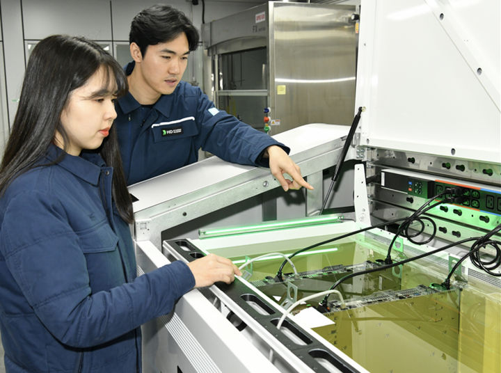 [서울=뉴시스] HD현대오일뱅크 직원들이 액침냉각설비에 담긴 냉각유와 서버를 테스트하고 있다.(사진제공=HD현대오일뱅크) 2025.04.30 photo@newsis.com *재판매 및 DB 금지