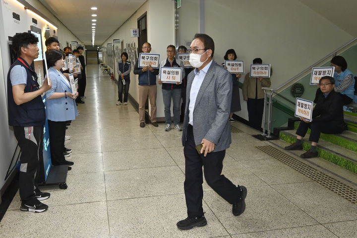 [광주=뉴시스] 박기웅 기자 = 30일 오전 의회사무국 직원에게 욕설 등 갑질 행위로 '공개 경고' 징계를 받은 김형수 광주 북구의회 의원이 본회의장에 들어서고 있다. 회의실 앞 복도에서 공무원 노조 조합원들이 손팻말 규탄 시위를 하고 있다. 2025.04.30. pboxer@newsis.com *재판매 및 DB 금지