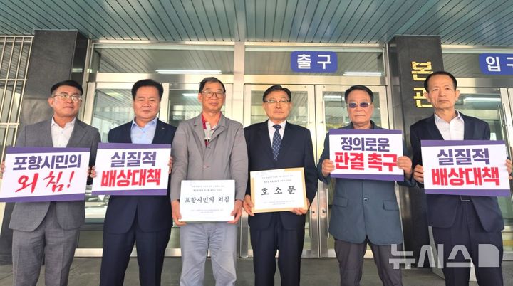 [포항=뉴시스] 송종욱 기자 = 포항지진범시민대책위는 30일 포항 촉발 지진 정신적 피해 손해 배상 항소심이 열리는 대구고등법원을 방문해 12개 시민 단체가 공동 서명한 호소문을 재판부에 제출했다. 사진은 12개 시민 단체 대표가 대구고등법원 본관 앞에서 호소문을 전달하며 기념 촬영하는 모습. (사진=포항시 제공) 2025.04.30. photo@newsis.com
