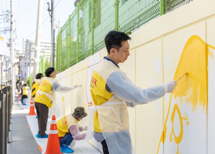 [서울=뉴시스] HDC현대산업개발이 5월 가정의 달을 앞두고 지역 주민과 함께 서울 송파초등학교의 '벚꽃길 담장' 벽화 그리기 봉사활동을 했다고 30일 밝혔다. (사진=HDC현산 제공) 2025.04.30. photo@newsis.com *재판매 및 DB 금지