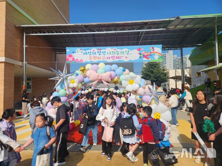 [여주=뉴시스]교문앞 레드카펫을 통과한 여주오학초등학교 어린이들이 즐거운 표정을 짓고 있다.(사진=오학초 제공)2025.04.30.photo@newsis.com