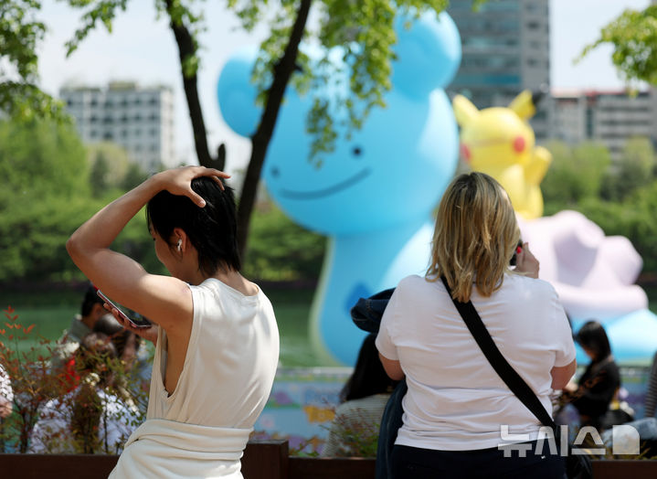 [서울=뉴시스] 김진아 기자 = 서울 낮기온이 26도로 초여름 더위를 보인 30일 서울 송파구 석촌호수에서 외국인 관광객들이 가벼워진 옷차림으로 시간을 보내고 있다. 2025.04.30. bluesoda@newsis.com