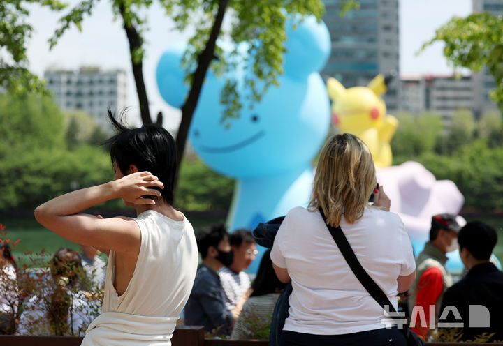 [서울=뉴시스] 김진아 기자 = 서울 낮기온이 26도로 초여름 더위를 보인 지난달 30일 서울 송파구 석촌호수에서 외국인 관광객들이 가벼워진 옷차림으로 시간을 보내고 있다. 2025.04.30. bluesoda@newsis.com