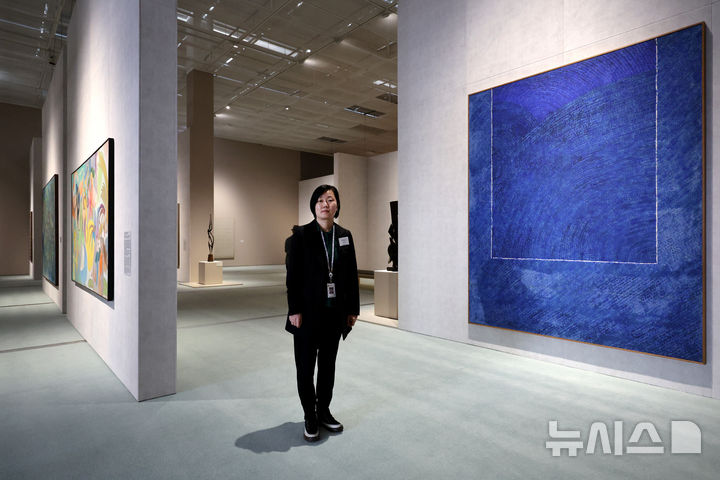 [서울=뉴시스] 박진희 기자 = 한국현대미술 하이라이트전시를 기획한 배명지 국립현대미술관 학예연구사가 김환기의 '산울림'(1973)작품앞에서 포즈를 취했다. pak7130@newsis.com