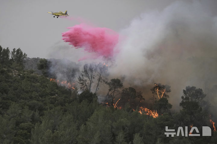[예루살렘=AP/뉴시스] 지난달 30일(현지 시간) 이스라엘 예루살렘 인근에서 발생한 산불 진압을 위해 소방 헬기가 방화제를 뿌리고 있다. 소방 당국은 1일 화재 발생 약 30시간 만에 진압에 성공했다고 발표했다. 2025.05.02.