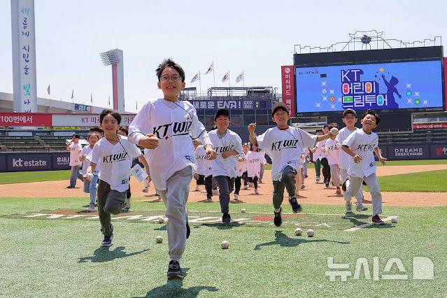 [서울=뉴시스]지난달 29일 수원KT위즈파크에서 진행된 KT 어린이 드림 투어 중 임직원 초등학생 자녀들이 레크리에이션을 즐기며 그라운드 위를 달리고 있다. (사진=KT 제공)