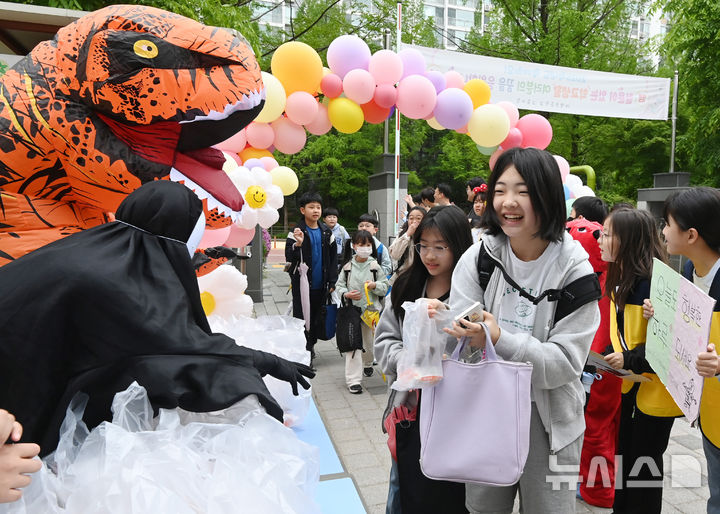 [수원=뉴시스] 김종택 기자 = 어린이날을 나흘 앞둔 1일 경기 수원시 대평초등학교에서 등교하는 학생들이 학부모들이 준비한 선물을 전달 받고 있다. 2025.05.01. jtk@newsis.com