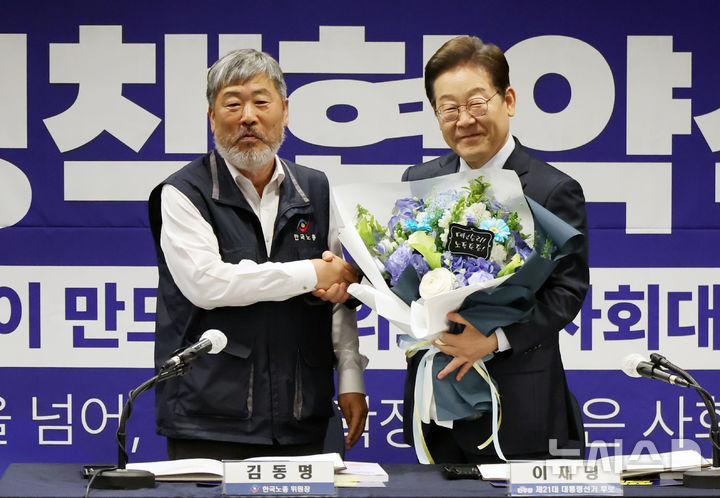 [서울=뉴시스] 조성우 기자 = 이재명 대통령이 더불어민주당대선후보 시절인 지난 5월 1일 오후 서울 중구 한국프레스센터에서 열린 한국노총 정책협약식에서 김동명 한국노총 위원장으로부터 꽃다발을 받은 뒤 기념촬영하고 있다. 2025.05.01. xconfind@newsis.com