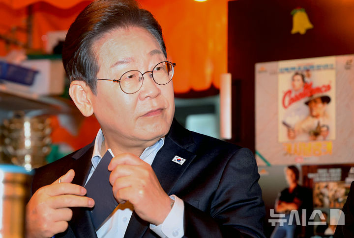 [서울=뉴시스] 조성우 기자 = 이재명 더불어민주당 대선후보가 1일 오후 서울 종로구의 한 포장마차에서 열린 비전형 노동자 간담회에서 수첩을 꺼내고 있다. 대법원 전원합의체는 이날 이 후보에게 무죄를 선고한 원심 판결을 파기하고 사건을 서울고법으로 돌려보냈다. (공동취재) 2025.05.01. photo@newsis.com