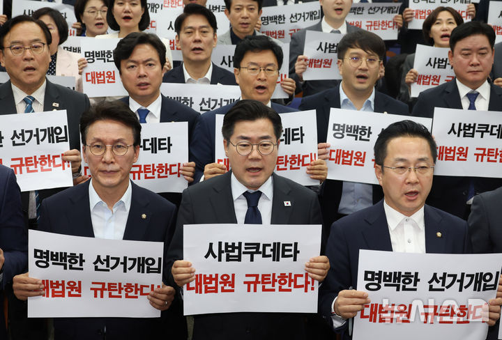 [서울=뉴시스] 조성봉 기자 = 박찬대 더불어민주당 대표 직무대행 겸 원내대표와 의원들이 1일 오후 서울 여의도 국회에서 열린 긴급 의원총회에서 손피켓을 들고 구호를 외치고 있다. 2025.05.01. suncho21@newsis.com