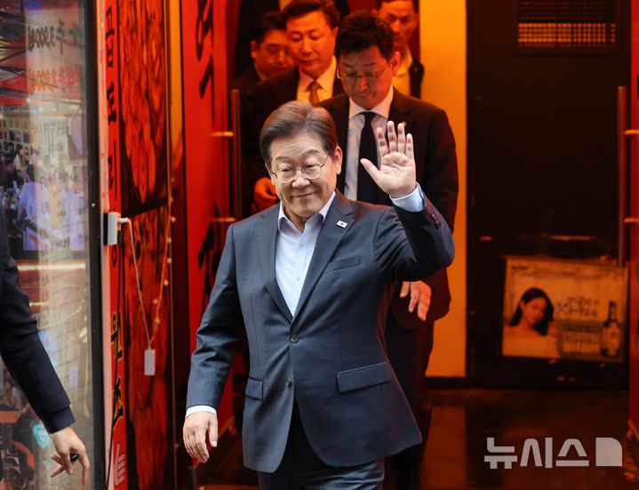 [서울=뉴시스] 조성우 기자 = 이재명 더불어민주당 대선후보가 지난 1일 오후 서울 종로구의 한 포장마차에서 열린 비전형 노동자 간담회를 마치고 나오며 손을 들어 보이고 있다. 대법원 전원합의체는 이날 이 후보에게 무죄를 선고한 원심 판결을 파기하고 사건을 서울고법으로 돌려보냈다. (공동취재) 2025.05.01. photo@newsis.com