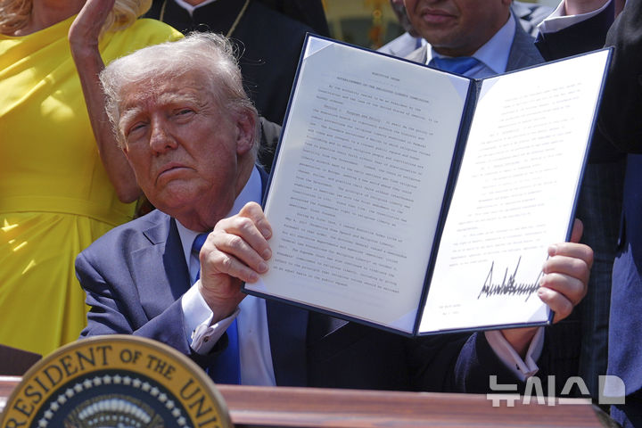 [워싱턴=AP/뉴시스] 도널드 트럼프 미국 대통령이 1일(현지 시간) 백악관 로즈가든에서 열린 국가 기도의 날 행사 중 '종교 자유 위원회' 설치 행정명령에 서명하고 있다. 트럼프 대통령은 공영 매체 PBS와 NPR 자금 지원을 축소하라는 내용의 행정명령을 발동했다. 2025.05.02.