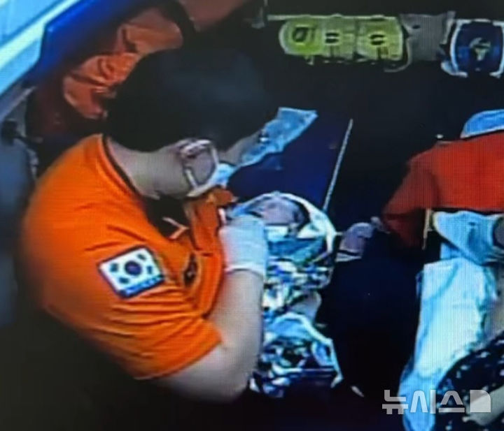 지난 4월 30일 오후 10시 44분께 정선에서 긴급 이송 중이던 119 구급차 안에서 구급대원이 산모의 출산을 도와 건강한 신생아를 들어보이고 있다.(사진=정선소방서 제공)