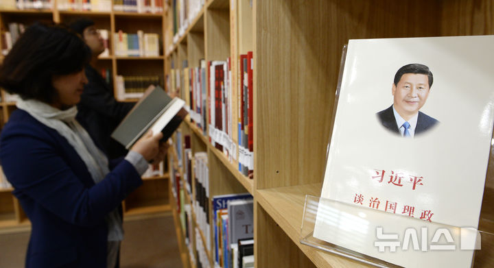 [서울=뉴시스] 추상철 기자 = 13일 오전 서울대학교 중앙도서관에서 열린 시진핑 주석 기증도서 자료실 개관식에서 참석자들이 책을 살펴보고 있다.시진핑 주석 기증도서 자료실에는 기증도서 1만여 권중 6천624권의 책이 비치됐으며 시 주석 방문 당시 강연내용 영상, 방명록, 서각 등이 함께 전시됐다. 2015.10,13.scchoo@newsis.com 