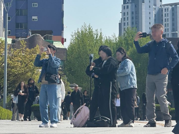 [서울=뉴시스] 주은서 인턴기자 = 지난달 25일 오후 이화여대 캠퍼스에서 외국인 관광객들이 학교 건물을 배경으로 사진을 찍고 있다. 2024.04.25. dmstj1654@naver.com *재판매 및 DB 금지