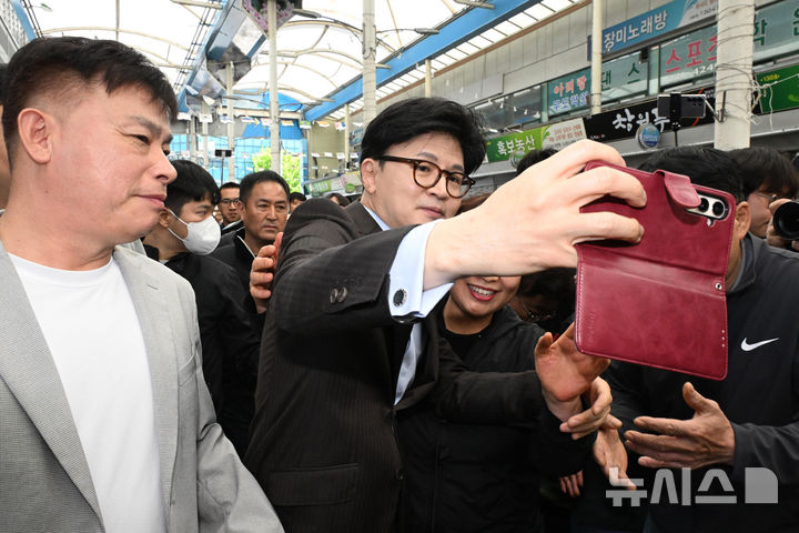 [창원=뉴시스] 차용현 기자 = 2일 오전 경남 창원시 마산어시장을 방문한 한동훈 제21대 대통령 선거 국민의힘 경선 후보가 시민과 기념촬영을 하고 있다. 2025.05.02.con@newsis.com