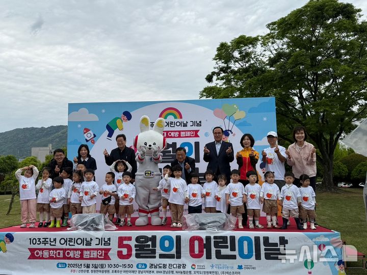 [창원=뉴시스]3일 경남도청 서편 잔디광장에서 열린 제103주년 어린이날 기념 '우리가 그리는 더 큰 꿈, 아이가치♡행복같이' 행사에 참석한 박명균(가운데) 행정부지사 등 주요 인사들이 합창을 마친 경남도청어린이집 원아 20여 명과 기념촬영하고 있다.(사진=경남도 제공) 2025.05.03. photo@newsis.com