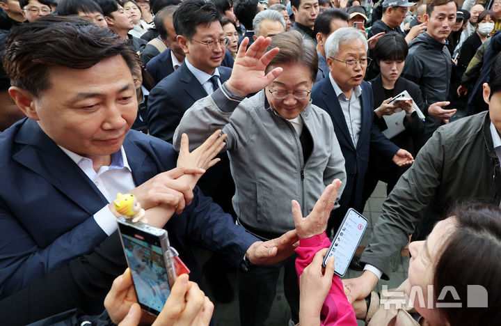 [양양=뉴시스] 조성우 기자 = 민심을 청취하는 '경청 투어'에 나선 이재명 더불어민주당 대선후보가 3일 강원도 양양군 양양시장에서 상인 및 주민들에게 인사를 하는 가운데 이 후보 경호원들 대인 직접 접촉을 차단하고 있다. 이 후보 측은 "후보에 대한 피습 모의 제보가 잇따르고 있다"고 밝혔다. 2025.05.03. xconfind@newsis.com