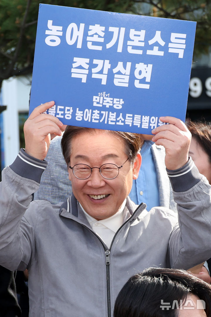 민심을 청취하는 '경청 투어'에 나선 이재명 더불어민주당 대선후보가 농어촌기본소득 즉각실현이라고 적힌 손팻말을 들어 보이고 있다. 2025.05.03. xconfind@newsis.com