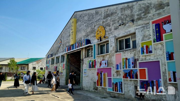 [청주=뉴시스] 충북 청주시와 청주시문화산업진흥재단은 4일 동부창고 일대에서 문화도시조성사업 '아카이브 시티 프로젝트' 기념식을 열었다. 동부창고 벽면에 문화도시 청주 5년의 사업들을 책으로 기록해 전시했다. (사진= 청주문화재단 제공) 2025.05.04. photo@newsis.com  *재판매 및 DB 금지