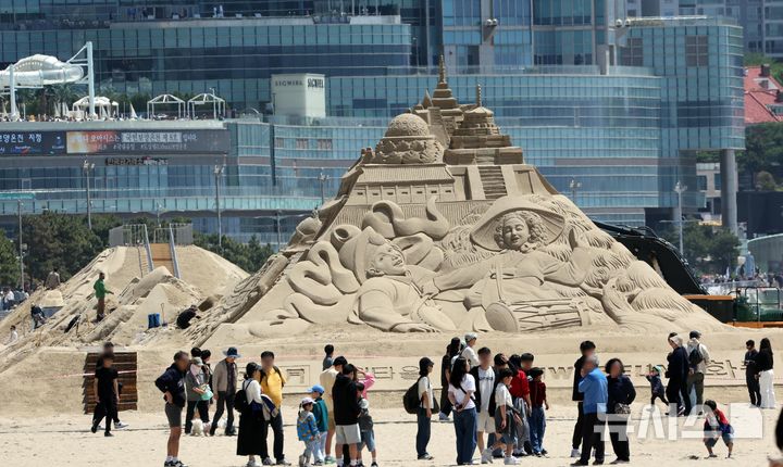 [부산=뉴시스] 하경민 기자 = 황금연휴 기간인 4일 부산 해운대구 해운대해수욕장을 찾은 시민과 관광객들이 다양한 모래조각 작품을 구경하고 있다.    해운대구는 오는 16~19일 '2025년 해운대 모래축제'를 개최한다. 올해 20주년을 맞은 모래축제는 '모래로 만나는 K-컬처'를 주제로 14명의 해외 모래 작가가 제작한 총 20여 개의 작품을 선보인다. 2025.05.04. yulnetphoto@newsis.com