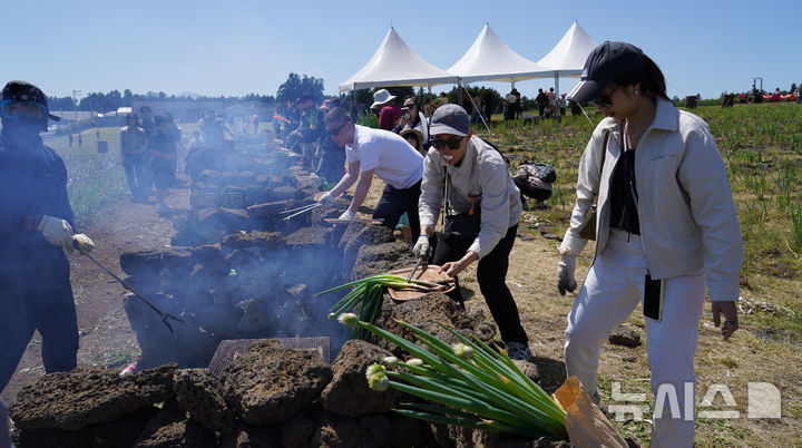 [서귀포=뉴시스] 우장호 기자 = 맑은 날씨를 보인 4일 오후 제주 서귀포시 표선면 보롬왓 농장에서 열린 '파릇파릇 대파축제'에서 입장객들이 대파 구워 먹기 체험을 하며 즐거운 시간을 보내고 있다. 2025.05.04. woo1223@newsis.com