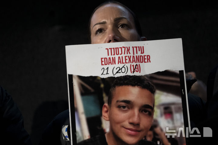 [텔아비브=AP/뉴시스]미국·이스라엘 이중국적 가자 인질 에단 알렉산더의 모친이 지난 2월22일 텔아비브에서 아들 사진을 들고 집회에 참석한 모습. 2025.05.12.