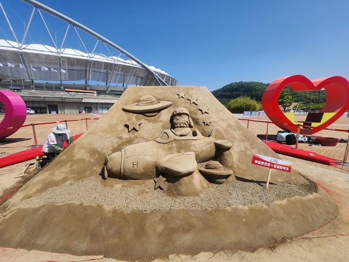 [진주=뉴시스] 지난 2일 제64회 경상남도민체육대회 개회식을 앞두고 진주시 인기 캐릭터 ‘하모와 아요’ 뒷면에는 최근 진주샛-1B발사에 성공한 것을 모티브로 하모가 비행기를 타고 우주여행을 하는 모습을 한국 최초 모래조각가 김길만 모래조각 작품이 진주종합경기장 야외전시장 전시돼 큰 인기를 모으고 있다.(사진= 한국모래예술학교 제공).2025.05.06.photo@newsis.com *재판매 및 DB 금지