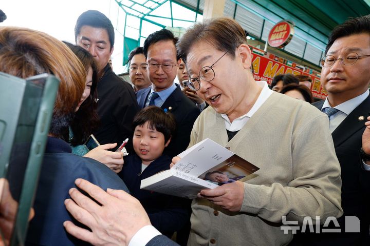 [증평=뉴시스] 조성봉 기자 = 민심을 청취하는 '경청 투어'에 나선 이재명 더불어민주당 대선후보가 6일 충북 증평군 장뜰시장에서 지지자에게 사인을 해주고 있다.(공동취재) 2025.05.06. photo@newsis.com