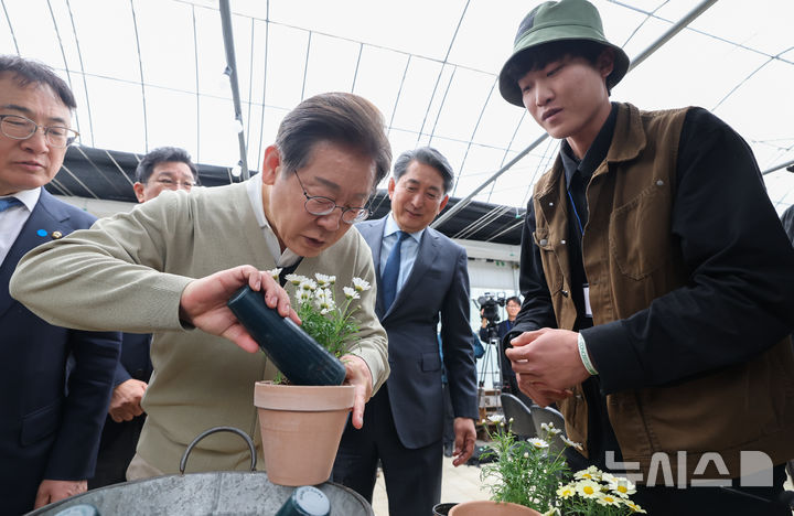 [보은=뉴시스] 조성봉 기자 = 민심을 청취하는 '경청 투어'에 나선 이재명 더불어민주당 대선후보가 6일 충북 보은군 화훼농원 숲결에서 분갈이 체험을 하고 있다. (공동취재) 2025.05.06. photo@newsis.com